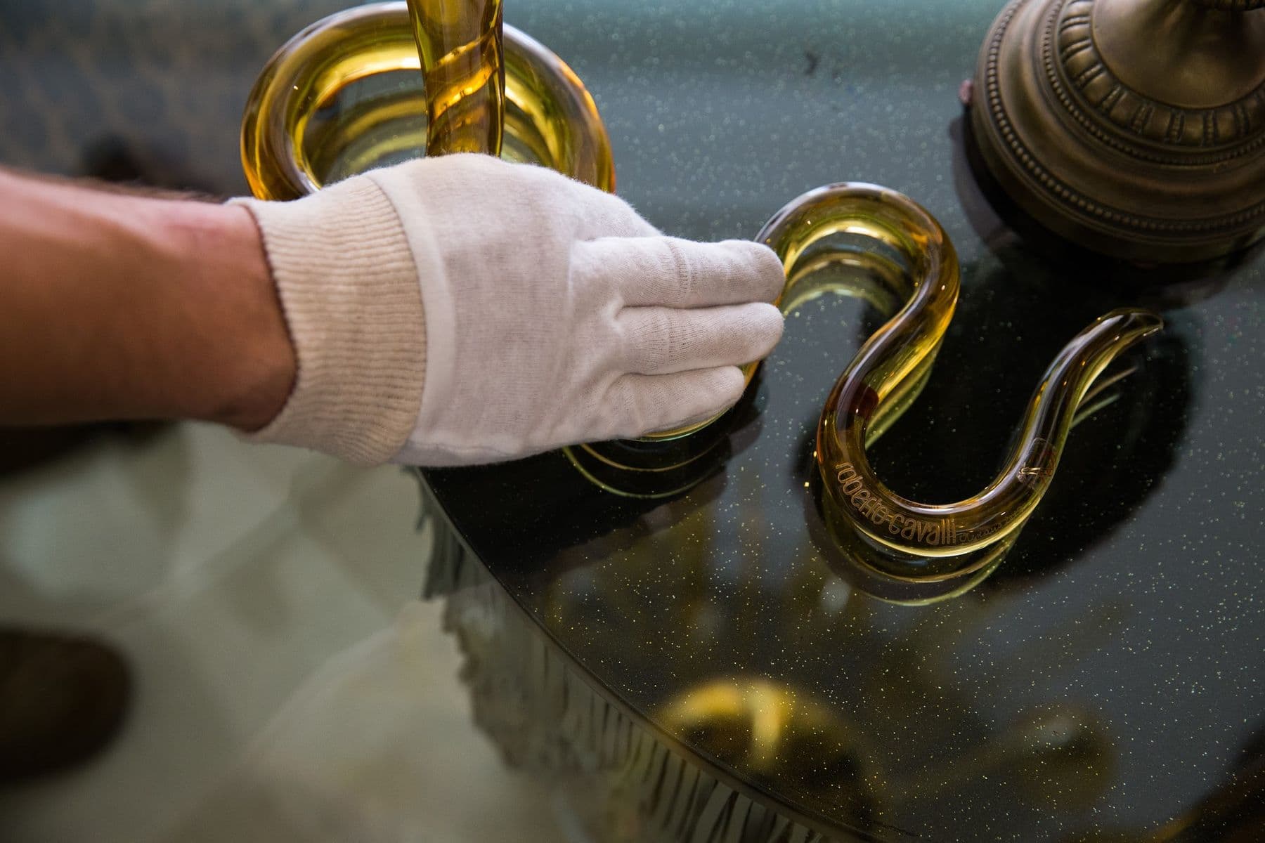 A gloved hand checking the finish on a piece during receiving.