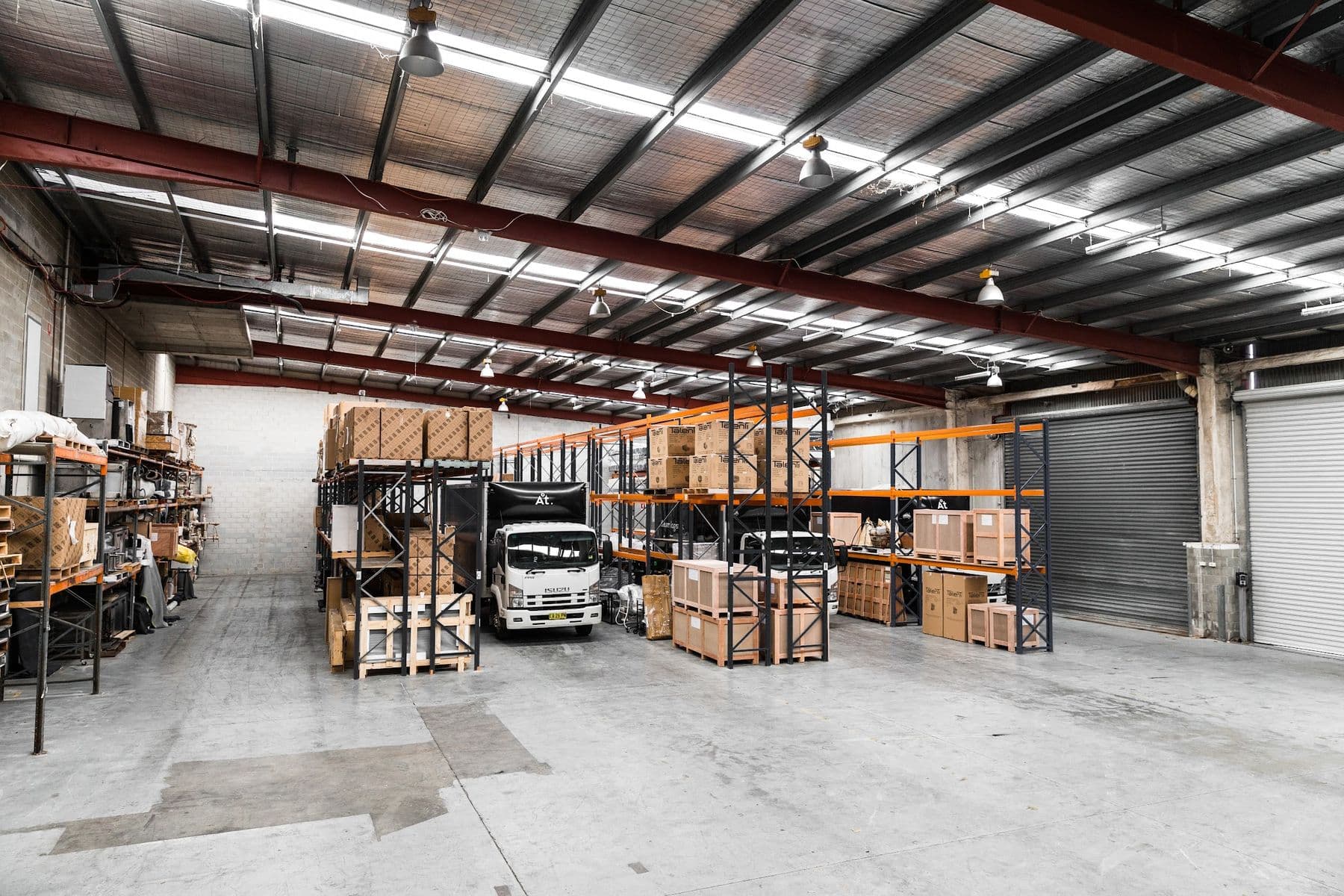 The interior of an Ateam Logistics warehouse with racking and trucks.